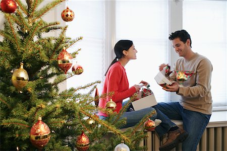 scambio dei regali di natale - Couple Opening Gifts on Christmas Fotografie stock - Rights-Managed, Codice: 700-00547273