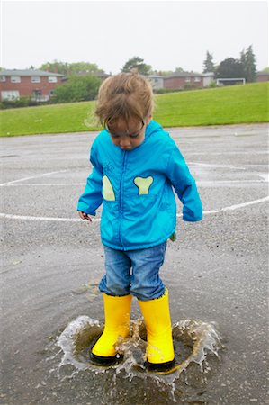 Enfant éclaboussures dans la flaque d'eau Photographie de stock - Rights-Managed, Code: 700-00549379