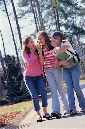 school girls talking gossip images - Girls Listening in on Cellular Phone, Whispering to One Another Stock Photo - Rights-Managed, Code: 700-00543808