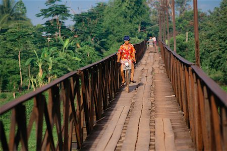 Woman Riding Bicycle on Bridge, Luang Prabang, Laos Stock Photo - Rights-Managed, Code: 700-00554819