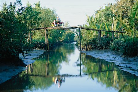 simsearch:862-06543131,k - Person Crossing Bridge Over Pond, Can Tho, Vietnam Stock Photo - Rights-Managed, Code: 700-00555631