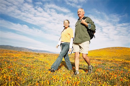 Couple Hiking Through Wildflowers Foto de stock - Con derechos protegidos, Código: 700-00552501