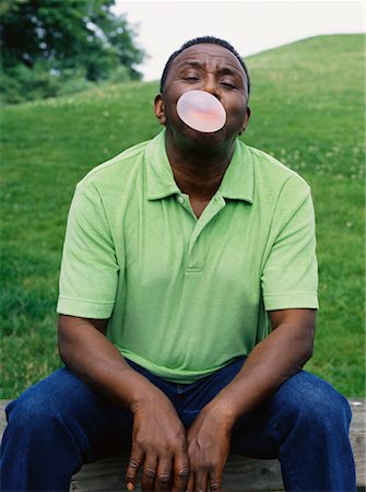 funny pictures people chewing gum - Man Sitting Blowing Bubbles Stock Photo - Rights-Managed, Code: 700-00560532
