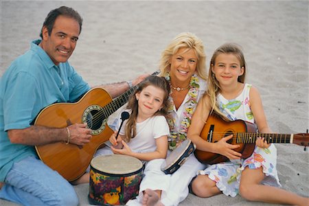 dad playing guitar with daughter - Famille jouant de la musique sur la plage Photographie de stock - Rights-Managed, Code: 700-00560913