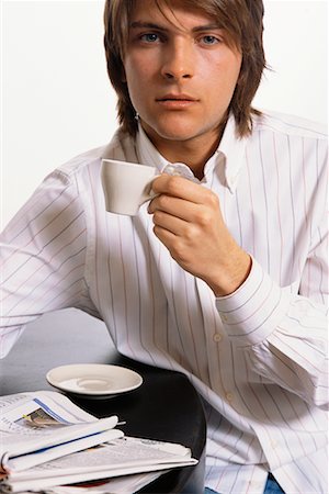 simsearch:700-02010670,k - Porträt des jungen Mann Kaffee trinken und Zeitung lesen Stockbilder - Lizenzpflichtiges, Bildnummer: 700-00561809