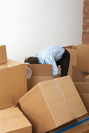 scotcher - Homme à la recherche dans des boîtes en carton Photographie de stock - Rights-Managed, Code: 700-00604407