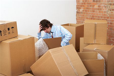 frustrated person and storage - Man Surrounded by Cardboard Boxes Stock Photo - Rights-Managed, Code: 700-00604409