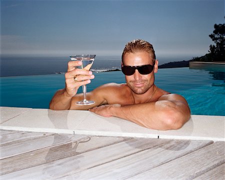 Man in Infinity Pool, Holding a Drink Foto de stock - Direito Controlado, Número: 700-00605045