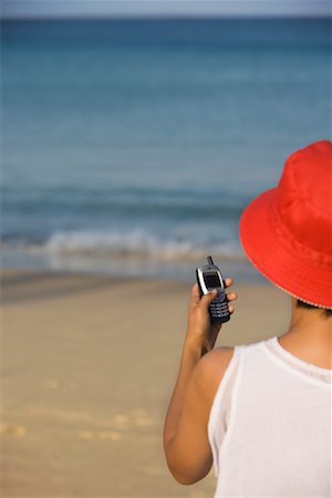 rear view of woman texting cellphone - Woman With Cellular Phone On The Beach Stock Photo - Rights-Managed, Code: 700-00605178