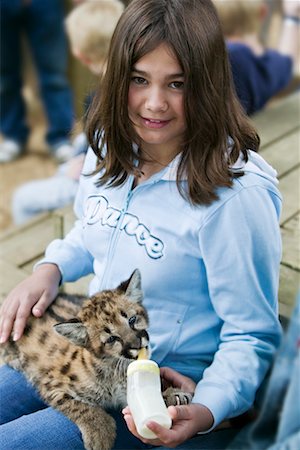 simsearch:400-05382792,k - Girl Feeding Baby Cougar At Petting Zoo Fotografie stock - Rights-Managed, Codice: 700-00609306