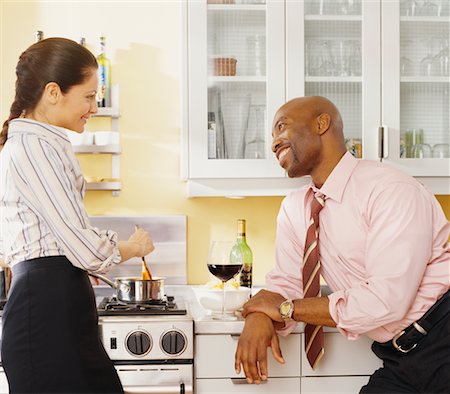 simsearch:693-03707644,k - Man Talking to Woman Cooking In Kitchen Foto de stock - Con derechos protegidos, Código: 700-00609986