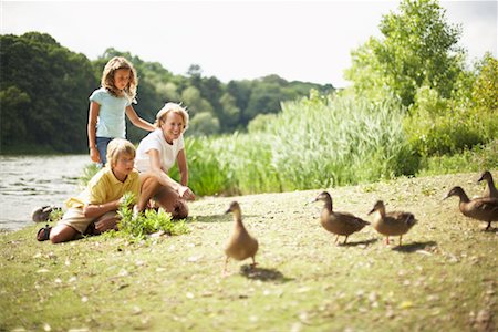 Grandmother and Grandchildren Feeding Ducks Stock Photo - Rights-Managed, Code: 700-00617215