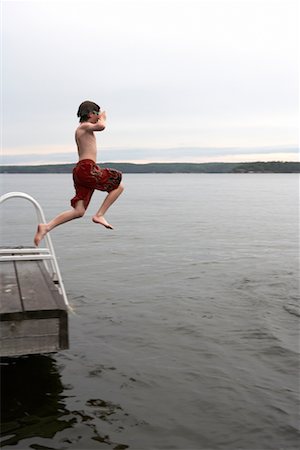 simsearch:632-06029801,k - Young Boy Jumping into Lake Foto de stock - Con derechos protegidos, Código: 700-00611105