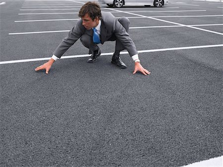 suit squat businessman - Businessman Crouching in Parking Lot Stock Photo - Rights-Managed, Code: 700-00644017