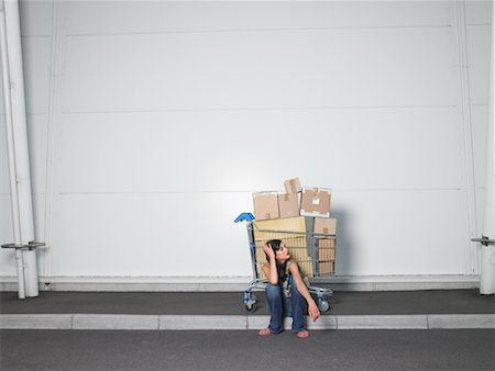 Woman Sitting on Curb With Grocery Cart Full of Boxes Stock Photo - Rights-Managed, Code: 700-00644049