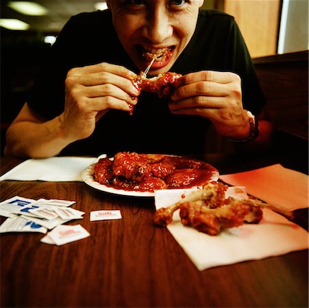 person eating chicken - Man Eating Chicken Wings Stock Photo - Rights-Managed, Code: 700-00661243