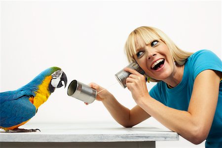 simsearch:700-00678796,k - Woman Offering Blue and Yellow Macaw Tin Can Telephone Stock Photo - Rights-Managed, Code: 700-00678822