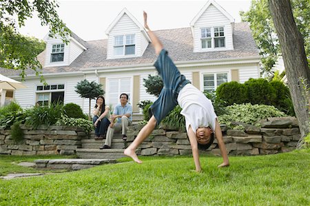family house three people outdoors play - Parents Watching Son in Front Yard Stock Photo - Rights-Managed, Code: 700-00686894