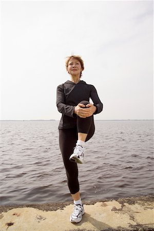 senior woman exercising by ocean - Woman Stretching By The Ocean Stock Photo - Rights-Managed, Code: 700-00688675