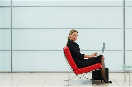 Femme d'affaires assis dans le fauteuil à l'aide d'ordinateur portable Photographie de stock - Rights-Managed, Code: 700-00681355