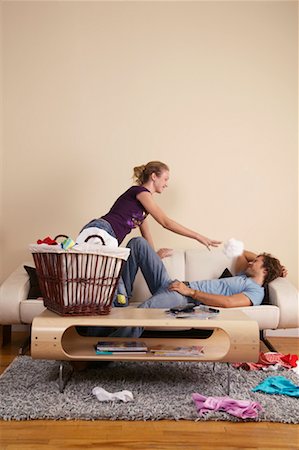 Femme jetant la lessive à l'homme Photographie de stock - Rights-Managed, Code: 700-00683269