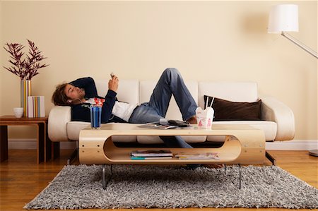 Man Listening to MP3 Player on Sofa Stock Photo - Rights-Managed, Code: 700-00683261