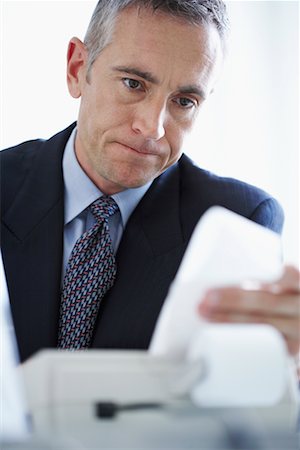 Man Looking at Adding Machine Print-Out Stock Photo - Rights-Managed, Code: 700-00695812