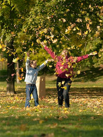 Woman and Girl Throwing Leaves Stock Photo - Rights-Managed, Code: 700-00695875