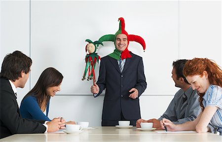 female humiliating male photo - Businessman Holding Meeting in Jester Costume Stock Photo - Rights-Managed, Code: 700-00748565