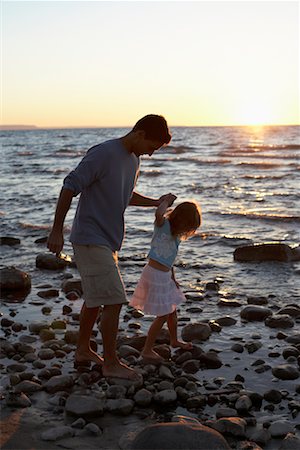 family holding hands on beach at sundown - Father and Daughter Walking on Beach Stones Stock Photo - Rights-Managed, Code: 700-00768233