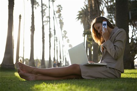 Femme d'affaires assis en plein air avec ordinateur portable et téléphone cellulaire Photographie de stock - Rights-Managed, Code: 700-00768342