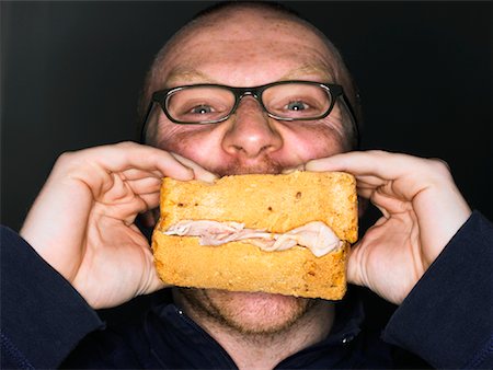 stuffed (people eating too much) - Man Eating Sandwich Stock Photo - Rights-Managed, Code: 700-00806814