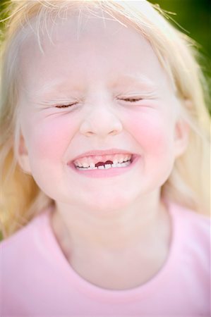 Portrait of Girl Smiling with Front Teeth Missing Stock Photo - Rights-Managed, Code: 700-00824961