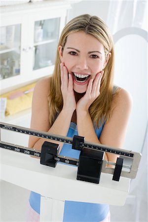 scales weight woman happy - Woman Standing on Scale Stock Photo - Rights-Managed, Code: 700-00823574