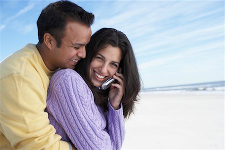 Man Hugging Woman Using Cell Phone Stock Photo - Rights-Managed, Code: 700-00847026