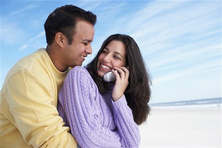 Man Hugging Woman Using Cell Phone Stock Photo - Rights-Managed, Code: 700-00847027