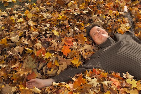 Man Lying on Pile of Leaves Stock Photo - Rights-Managed, Code: 700-00847670