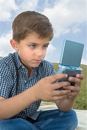 Boy Playing Portable Video Game Stock Photo - Rights-Managed, Code: 700-00848295