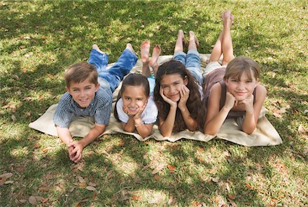 Portrait des enfants se trouvant sur la couverture dans le parc Photographie de stock - Rights-Managed, Code: 700-00864729