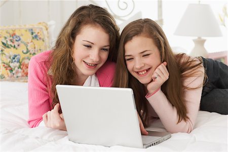 Girls Lying on Bed, Using Laptop Stock Photo - Rights-Managed, Code: 700-00865136