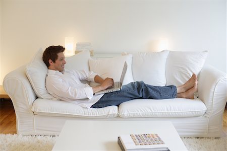 Man Using Laptop on Sofa Stock Photo - Rights-Managed, Code: 700-00865642