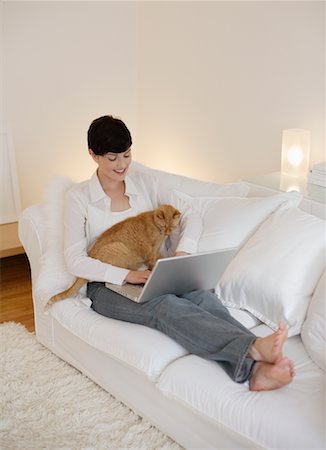 Woman Sitting on Sofa With Cat Foto de stock - Con derechos protegidos, Código: 700-00865684