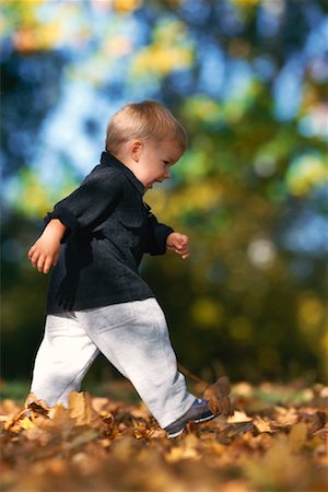 Child Walking through Leaves Stock Photo - Rights-Managed, Code: 700-00910953