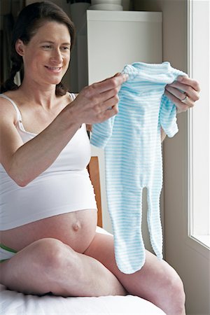 simsearch:700-00935169,k - Pregnant Woman Holding Baby Clothes Foto de stock - Con derechos protegidos, Código: 700-00935150