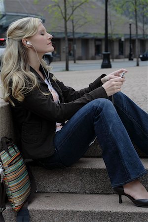 Woman Using MP3 Player Outdoors Stock Photo - Rights-Managed, Code: 700-00955221