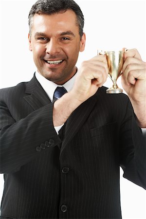 sinal de sucesso - Businessman Holding Trophy Foto de stock - Direito Controlado, Número: 700-01015003