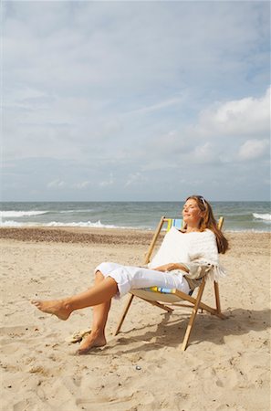simsearch:700-00897432,k - Woman sitting in Canvas, Beach Chair, on Beach Foto de stock - Con derechos protegidos, Código: 700-01042839
