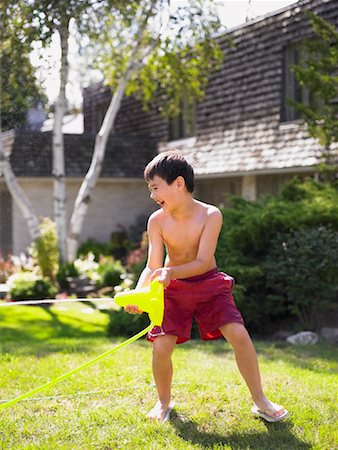 simsearch:700-01124285,k - Boy Playing With Sprinkler Foto de stock - Con derechos protegidos, Código: 700-01043517