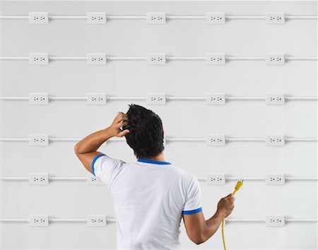 electrical plugs inside socket - Man Trying to Figure Out Which Electrical Socket to Use Stock Photo - Rights-Managed, Code: 700-01072770