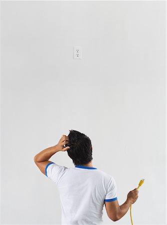 scratching head - Man Trying to Figure Out How to Reach Electrical Socket Stock Photo - Rights-Managed, Code: 700-01072771